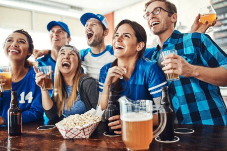 Téléchargez les photos : Les fans de sport font ce qu'ils font le mieux. un groupe d'amis buvant des bières en regardant un match de sport dans un bar - en image libre de droit