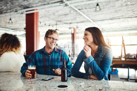 Foto de Qué gran manera de empezar el fin de semana. una pareja disfrutando de una copa en un bar - Imagen libre de derechos