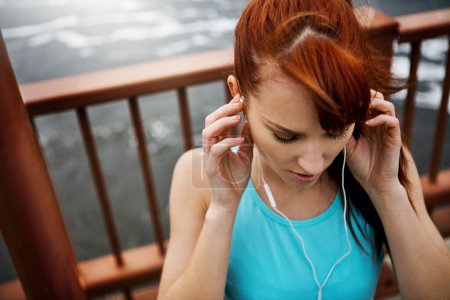 Foto de Mantenerse saludable y en forma con la banda sonora perfecta. una joven deportista escuchando música mientras sale a correr por la ciudad - Imagen libre de derechos