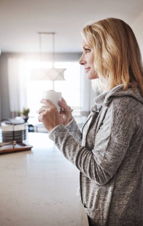 Téléchargez les photos : Les matins étaient faits pour le café. une femme mûre se relaxant à la maison avec une tasse de café - en image libre de droit