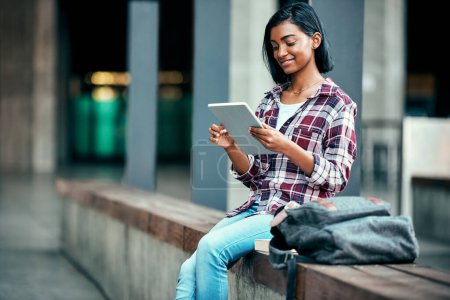 Photo for Great spots all around campus to study. a young female student using a tablet outside on campus - Royalty Free Image