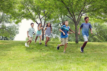 Foto de Corre a la diversión. un grupo de jóvenes amigos corriendo por un terraplén en el parque - Imagen libre de derechos