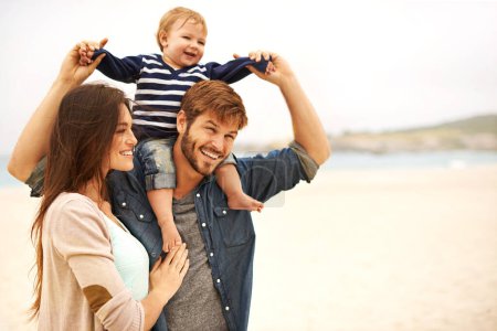 Photo for Love and baby with parents at a beach for piggyback, fun and walking in nature. Family, kid and happy woman with man outdoors bonding, smile and relax while enjoying travel, freedom or game. - Royalty Free Image