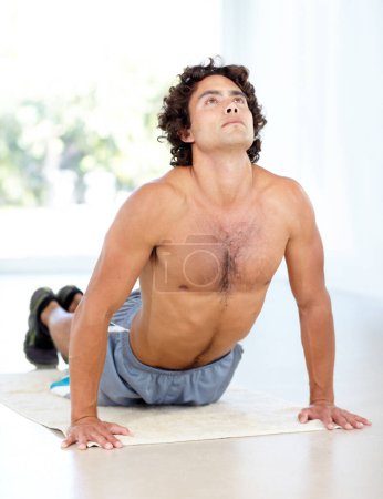 Photo for Yoga, man and cobra stretch in home for health, wellness and flexibility in house. Pilates, stretching and male person, yogi or athlete training, holistic workout and exercising for fitness on mat - Royalty Free Image