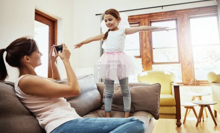 Téléchargez les photos : Chérissez les moments précieux avec vos enfants. une mère prenant une photo de sa petite fille s'amusant à la maison - en image libre de droit