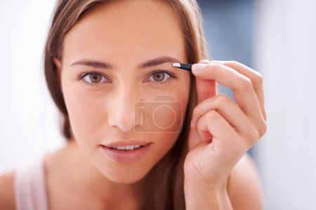 Photo for Woman, tweezers and eyebrows in bathroom portrait for skincare, beauty or cosmetics for face in home. Girl, facial hair removal and cosmetic tools for brows, aesthetic or wellness in morning at house. - Royalty Free Image