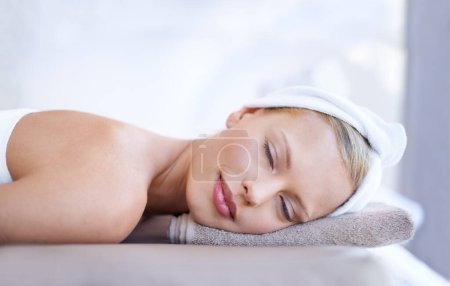 Photo for Spa massage, relax and face of a woman on a bed for beauty, dermatology or skincare. Female client on a table with a towel and peace for luxury cosmetics, zen treatment or health and wellness. - Royalty Free Image