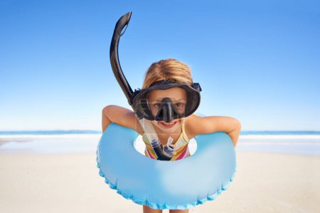 Photo for Portrait, beach and child with goggles and inflatable gear for swimming, summer holiday and happy outdoor adventure. Face of kid excited standing by the ocean or sea water excited for vacation. - Royalty Free Image