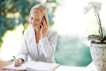 Photo for Woman, phone call and receptionist taking notes, smile and listening to contact. Cellphone, notebook and female secretary writing, booking schedule and appointment for hotel, spa and communication - Royalty Free Image