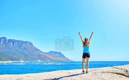 Photo for Nothing can get in the way of determination. a young woman celebrating her victory while out for a run - Royalty Free Image