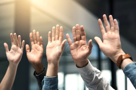 Foto de Levanta las manos si apoyas a tu equipo. un grupo de empresarios irreconocibles levantando la mano - Imagen libre de derechos