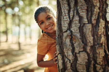 Foto de El parque es su lugar favorito para jugar. Retrato de una niña jugando en el bosque - Imagen libre de derechos