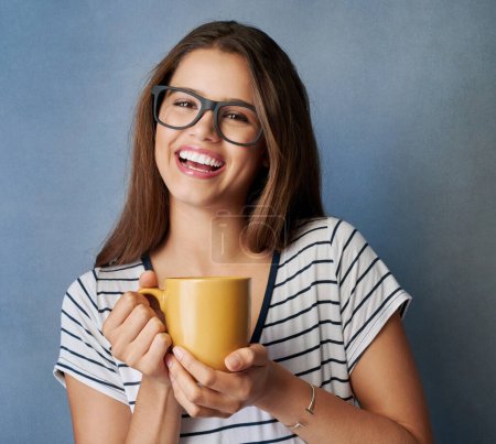 Foto de No puedes estar gruñón con el café en la mano. Foto de estudio de una joven atractiva sosteniendo una taza de café sobre un fondo gris - Imagen libre de derechos