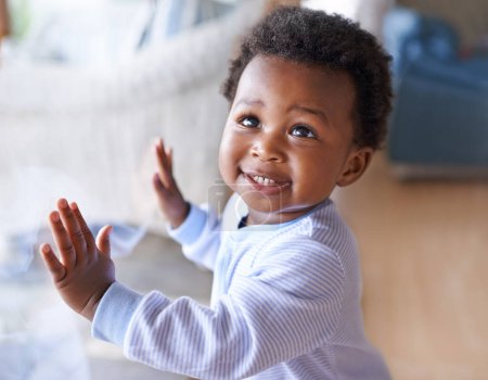 Foto de Niño negro feliz, desarrollo de la infancia y el niño con sonrisa de pie contra la ventana en el hogar de la familia. Felicidad con el niño africano, el crecimiento y el niño lindo en casa con cuidado de niños. - Imagen libre de derechos