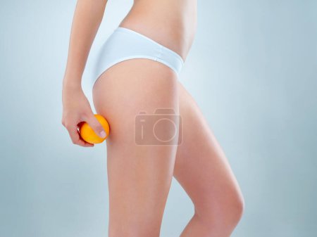 Photo for Its the secret to my success. an unidentifiable young woman posing in her underwear while holding an orange in studio - Royalty Free Image