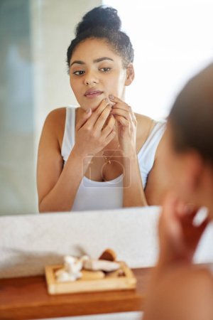 Foto de Puede que necesite algo de cobertura para esto. una joven mujer apretando una espinilla delante del espejo del baño - Imagen libre de derechos