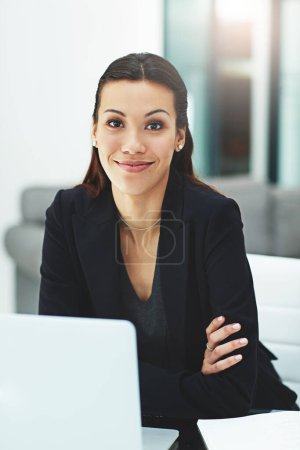 Photo for Do what you love and it wont feel like work. Portrait of a young businesswoman working with her laptop in the office - Royalty Free Image