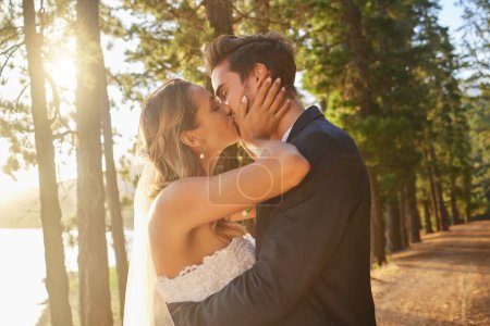 Photo for Wedding, love and couple and kiss in park, forest and nature for celebration of union, care and marriage. Bride, groom and kissing in garden for romance, intimate bridal event or celebrate commitment. - Royalty Free Image