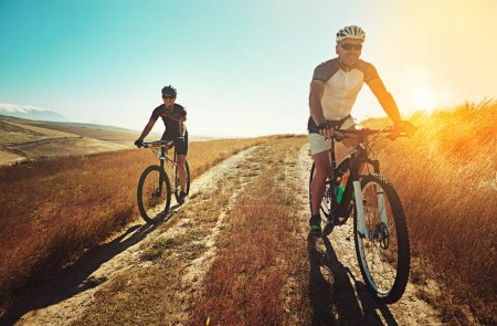 Téléchargez les photos : Commencez votre journée avec un peu de VTT. deux cyclistes à vélo à la campagne - en image libre de droit