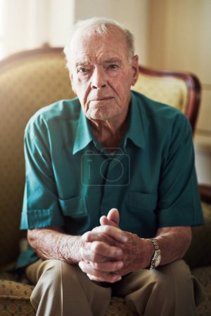 Photo for Its not so bad once you get used to it. Cropped portrait of a senior man sitting by himself in a living room - Royalty Free Image