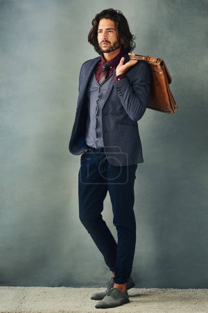 Téléchargez les photos : Style professionnel. Plan studio d'un beau jeune homme élégamment habillé avec son sac par-dessus son épaule - en image libre de droit