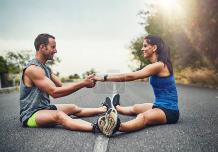 Photo for Stretching has become a way of communication for us. a young attractive couple training for a marathon outdoors - Royalty Free Image