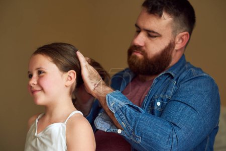 Foto de Peinado de papá. un padre cepillando el pelo de sus hijas en casa - Imagen libre de derechos