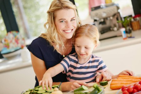 Photo for Shes a great little helper. Portrait of a mother and daughter preparing a meal together at home - Royalty Free Image