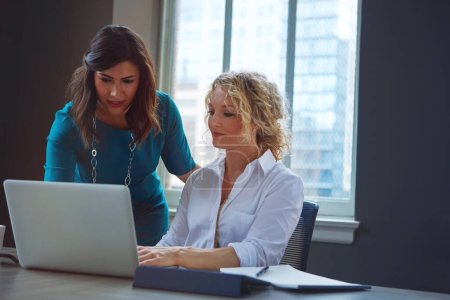 Photo for Offering guidance and encouragement. two businesswomen using a laptop together in an office - Royalty Free Image