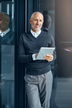 Foto de Cuando dejas de soñar dejas de vivir. un hombre de negocios maduro usando su tableta digital en la oficina - Imagen libre de derechos