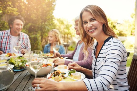 Photo for Lunch with my lovelies. Portrait of a happy woman enjoying an outdoor lunch with her family - Royalty Free Image