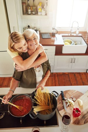 Foto de El ingrediente secreto es siempre el amor. una mujer mayor y su hija cocinando en la cocina - Imagen libre de derechos