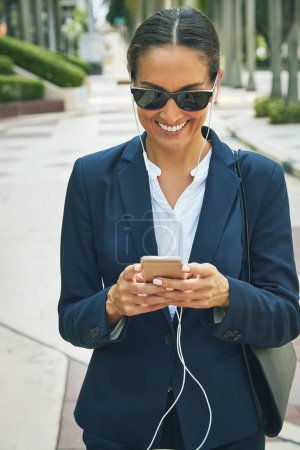 Photo for She just got an email notification. a young businesswoman using her phone while out in the city - Royalty Free Image