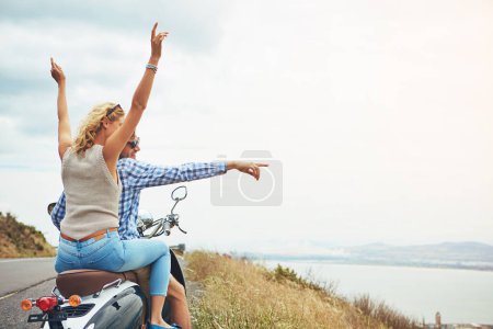 Téléchargez les photos : Prenez toujours la route panoramique. un jeune couple pour une balade en scooter - en image libre de droit