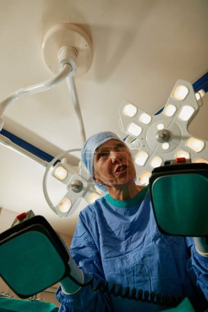 Téléchargez les photos : Dégagez. un chirurgien utilisant un défibrillateur pendant la chirurgie - en image libre de droit