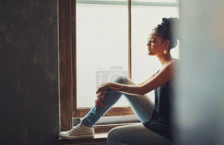 Photo for The perfect place to catch the view. an attractive young woman sitting by the window - Royalty Free Image