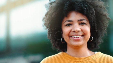 Téléchargez les photos : Une étudiante journaliste africaine confiante est heureuse de son succès en classe. Une jeune journaliste noire sourit et rit de bonnes histoires. Fière auteure excitée par sa carrière. - en image libre de droit
