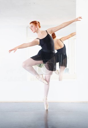 Foto de Bailarina, ballet y mujer está bailando en clase, joven bailarina en ensayo con arte y gracia en el estudio. Persona femenina en pose puntiaguda, equilibrio y entrenamiento para el rendimiento con creatividad y fitness. - Imagen libre de derechos