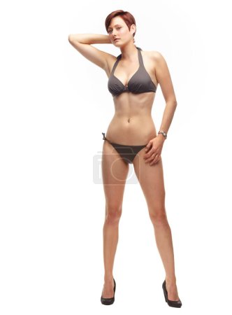 Foto de Sexy confianza en sí mismo. Sexy cabeza roja posando en tacones y un bikini-Studio shot - Imagen libre de derechos