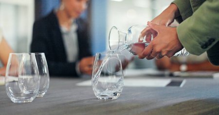 Téléchargez les photos : Business staff, hands and pouring water into glass of a employee ready for a meeting. Drink, office workers and conference room table with employee group and strategy documents for discussion. - en image libre de droit