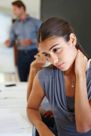 Téléchargez les photos : Quelle charge de travail. Jeune femme d'affaires dans une réunion regardant stressé avec sa main sur son cou - en image libre de droit