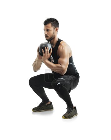 Photo for Working every muscle in his body. Studio shot of a fit young man working out with a kettle bell against a white background - Royalty Free Image