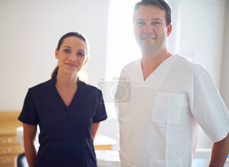 Photo for Always great to see your smile around the office. Cropped portrait of a dentist standing with his assistant - Royalty Free Image