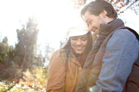 Foto de Sintiendo el amor. Una pareja joven y cariñosa de pie al aire libre en el bosque - Imagen libre de derechos