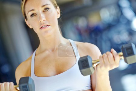 Photo for Im making great progress. A beautiful young woman working out at the gym - Royalty Free Image