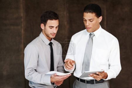 Foto de Dando algunos consejos corporativos sabios. Dos hombres de negocios profesionales discutiendo usando una tableta digital - Imagen libre de derechos