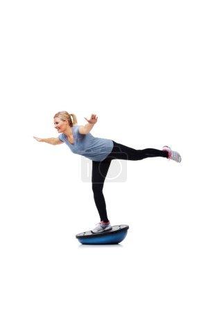 Foto de Su rutina diaria de ejercicios. Una hermosa joven de pie sobre una bola de bosu mientras hace ejercicio - Imagen libre de derechos