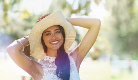 Foto de Proteger mi piel contra el sol del verano. Una joven feliz de pie en el parque con un sombrero de sol - Imagen libre de derechos