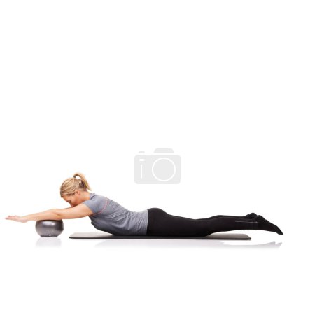 Photo for The variety of exercise a ball affords is amazing. A young woman using an exercise ball while lying down - isolated - Royalty Free Image