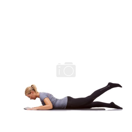 Téléchargez les photos : Elle travaille ses jambes. Une jeune femme en forme travaillant sur son tapis d'exercice sur un fond blanc - en image libre de droit
